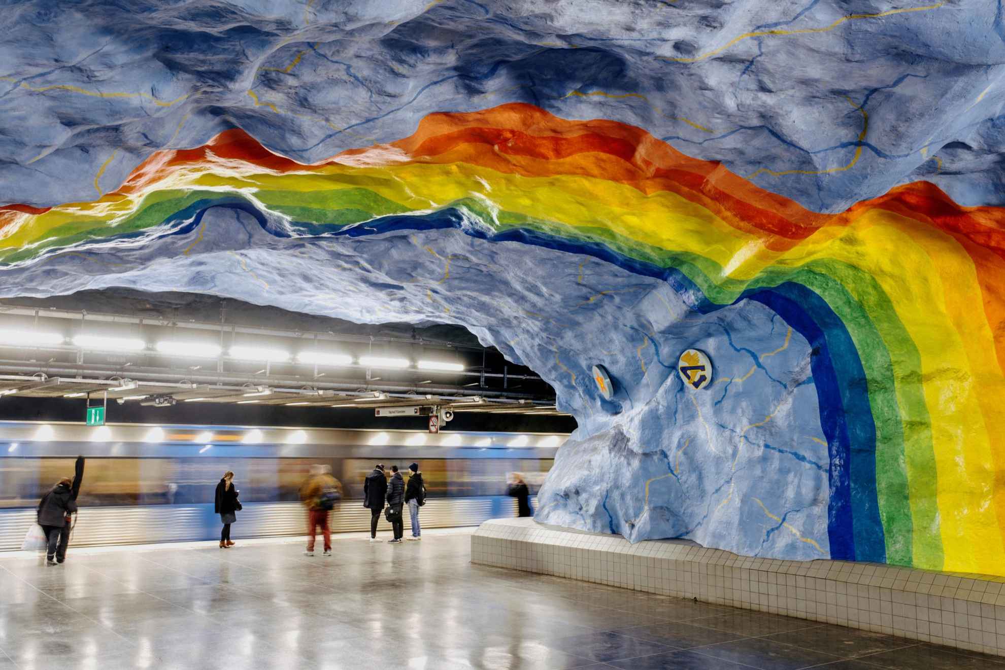 Ein Regenbogen in lebhaften Farben, der in einer U-Bahnstation an die Decke gemalt ist.