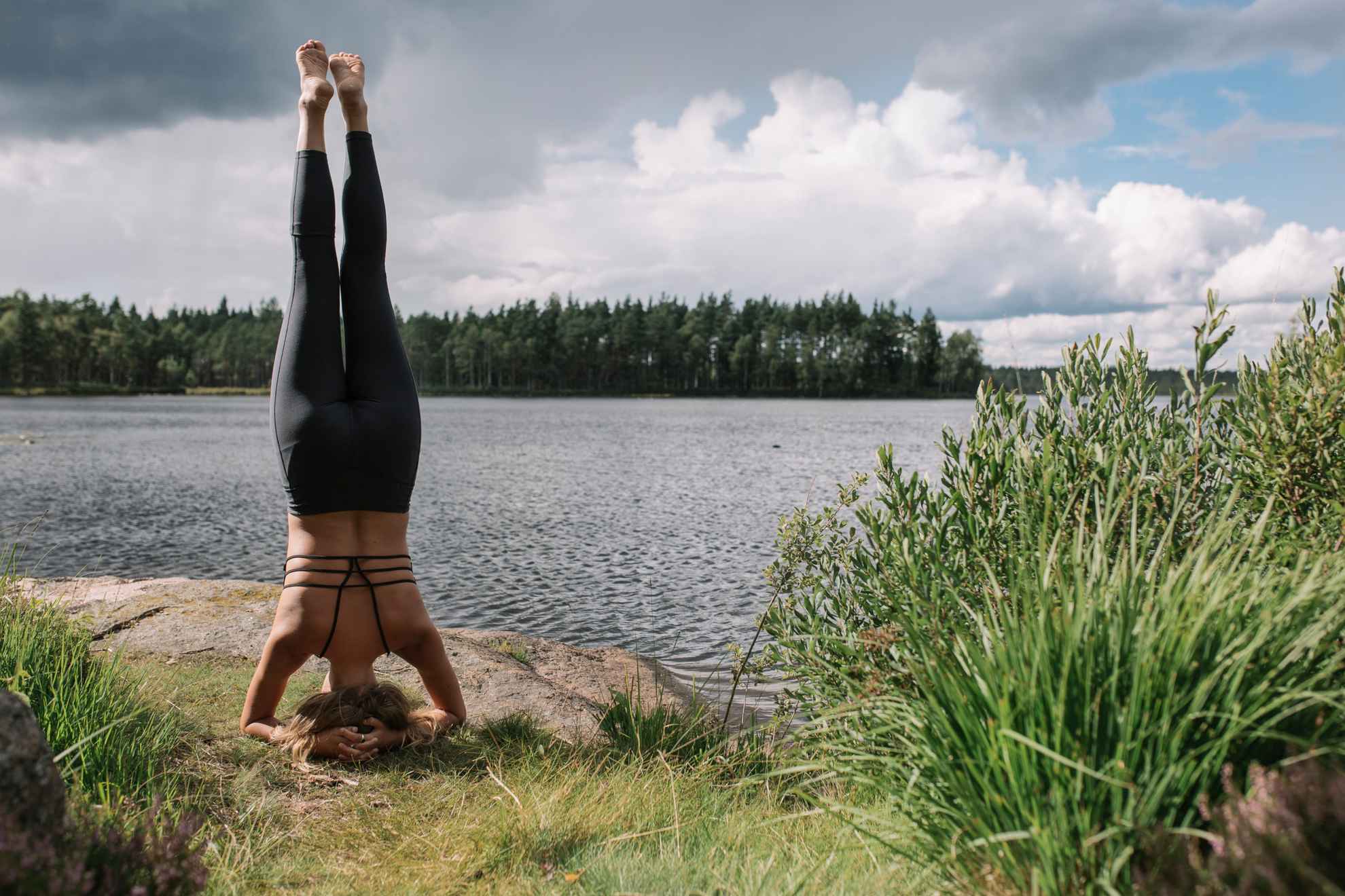 Eine Frau macht Yoga an einem See in Schweden.