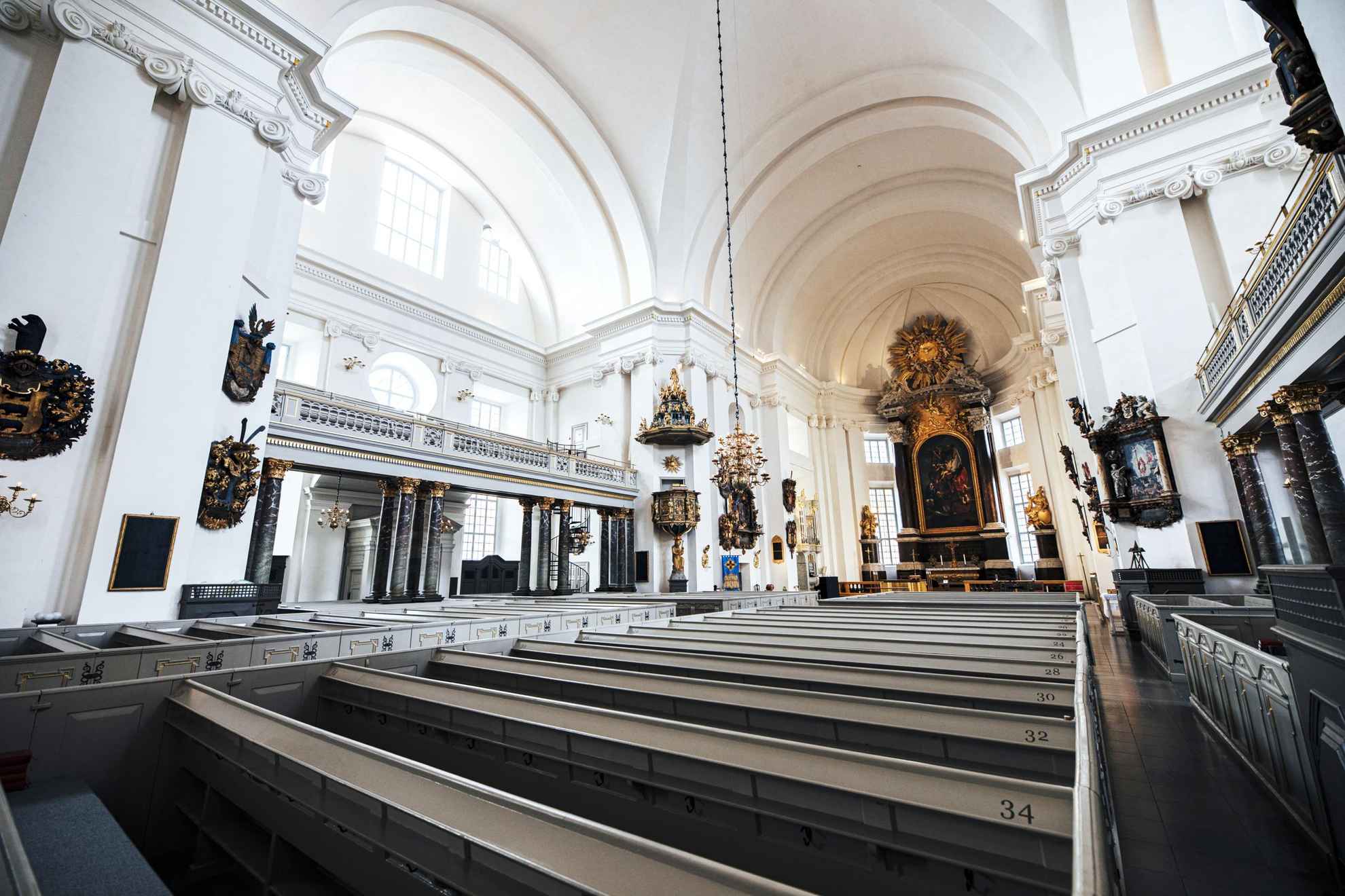 Das Innere der Kathedrale in Kalmar ist im Barockstil mit weißen Wänden und vielen goldenen Verzierungen gehalten.