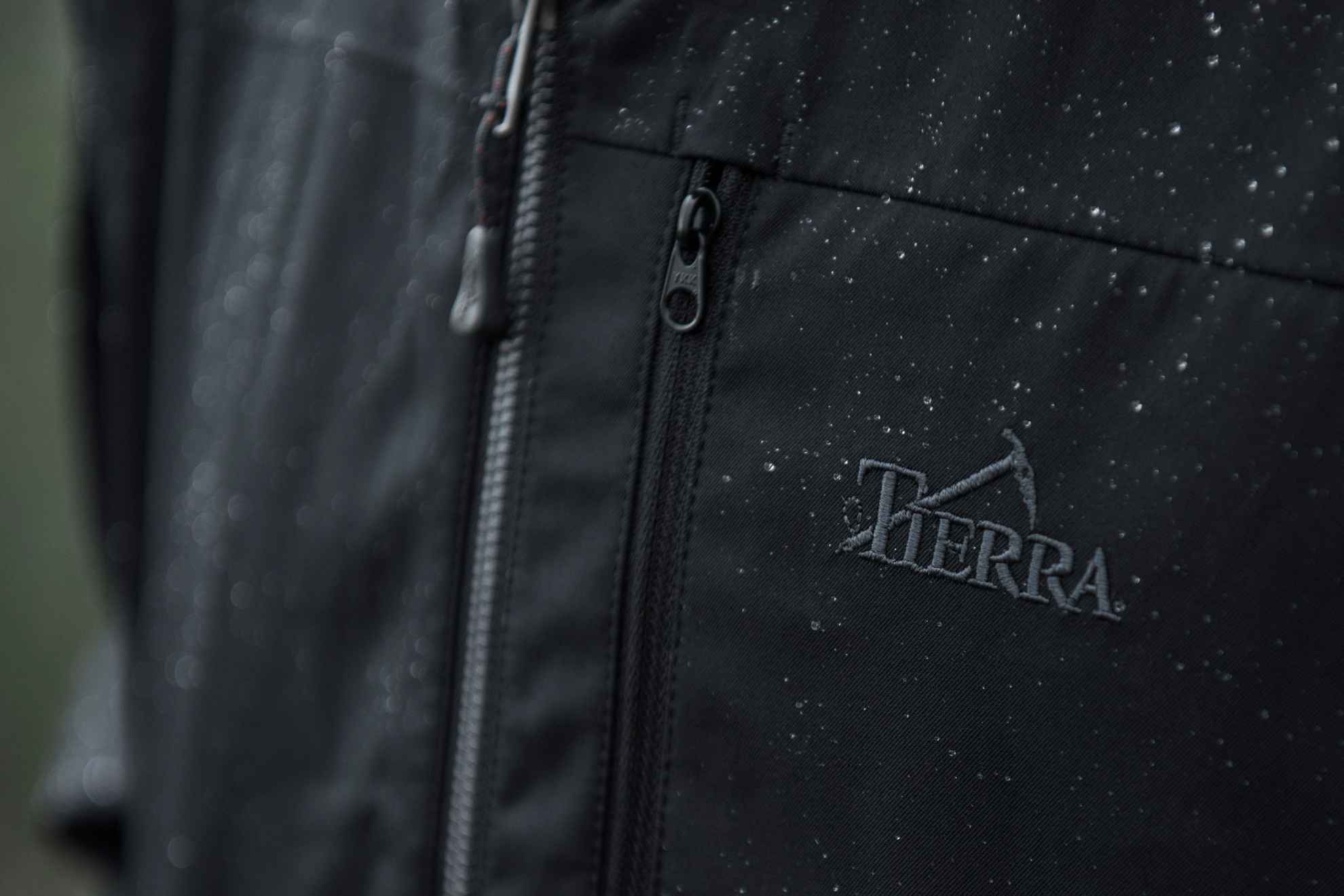 Nahaufnahme einer schwarzen Regenjacke mit dem Logo Tierra.