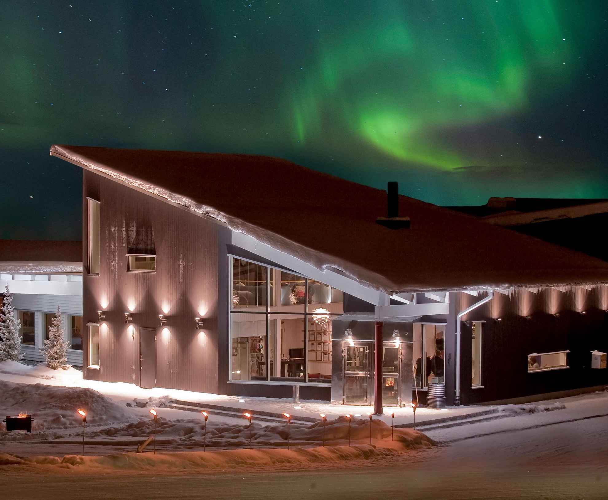Das Nordlicht tanzt nachts am Winter am Himmel über dem Camp Ripan in Kiruna.
