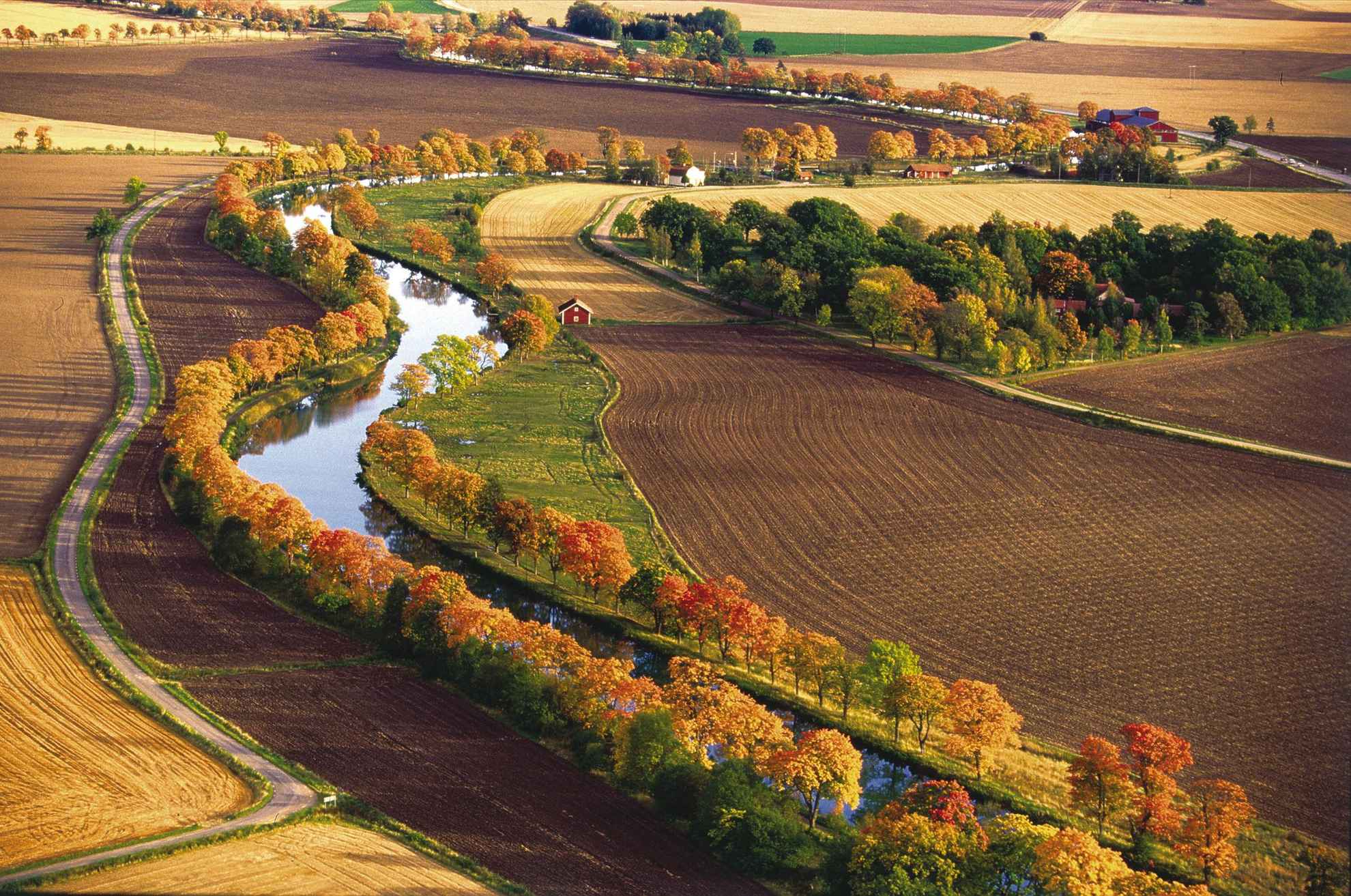 Herbstlich gefärbte Baumalleen säumen das Ufer des geschwungenen Göta Kanals.
