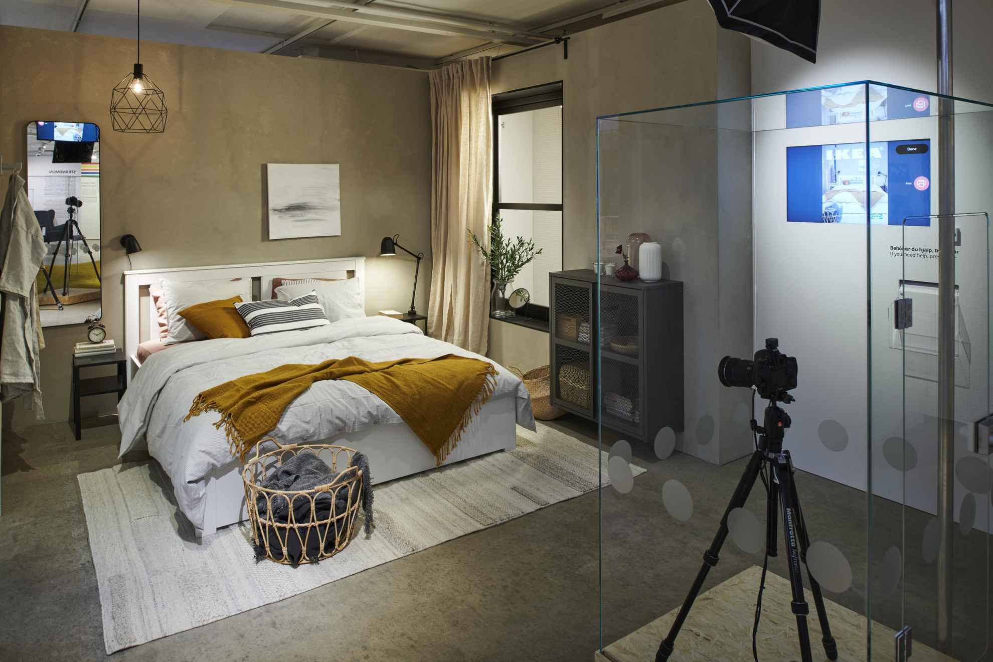 Im IKEA-Museum. Ein Schlafzimmer mit Doppelbett, Lampen und einem kleinen Schrank. Eine Kamera in einem Glasschrank.