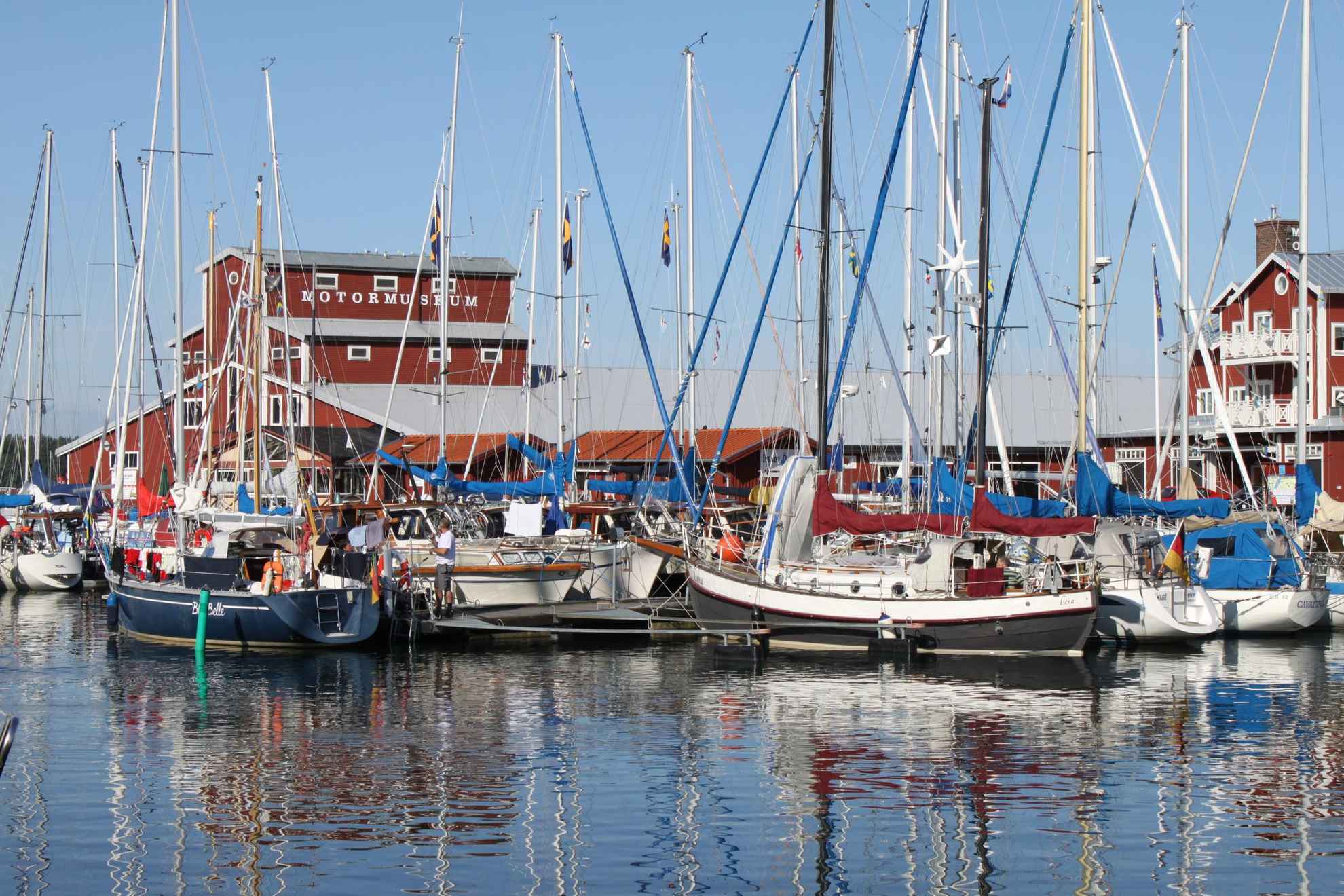 Ein Hafen mit mehreren Segelbooten, die an einem Steg angedockt sind.