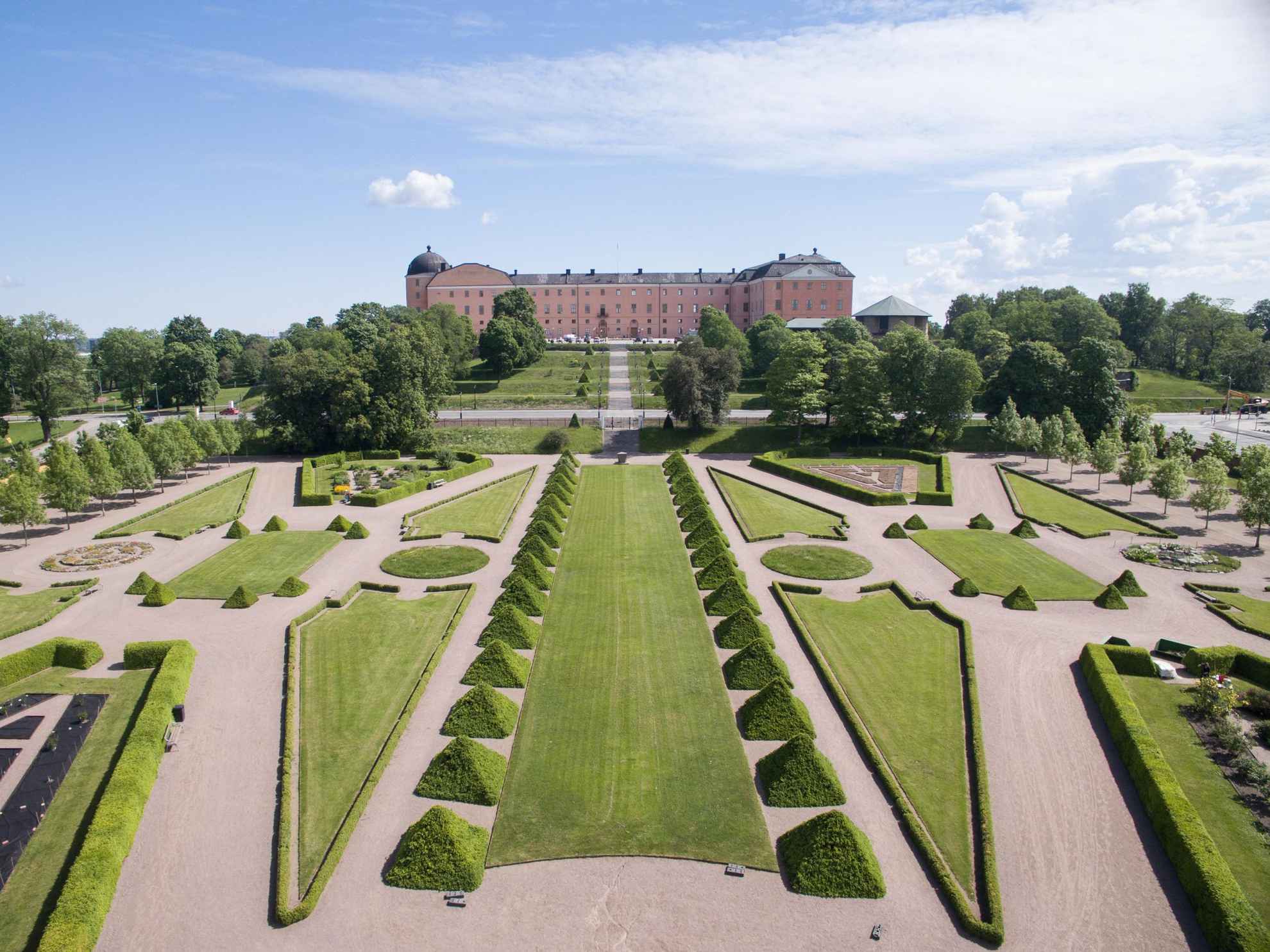 Ein wunderschöner Garten mit Rasen und Gartenkunst vor dem Schloss von Uppsala.