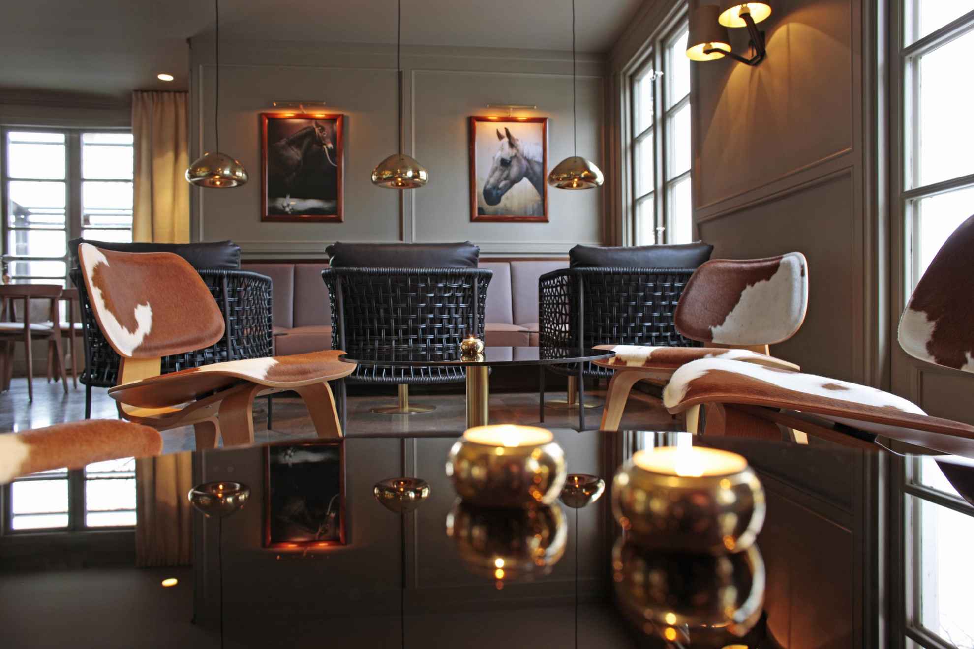Ein Lounge-Bereich in einem Hotel ist mit Möbeln in warmen Kupfertönen eingerichtet.