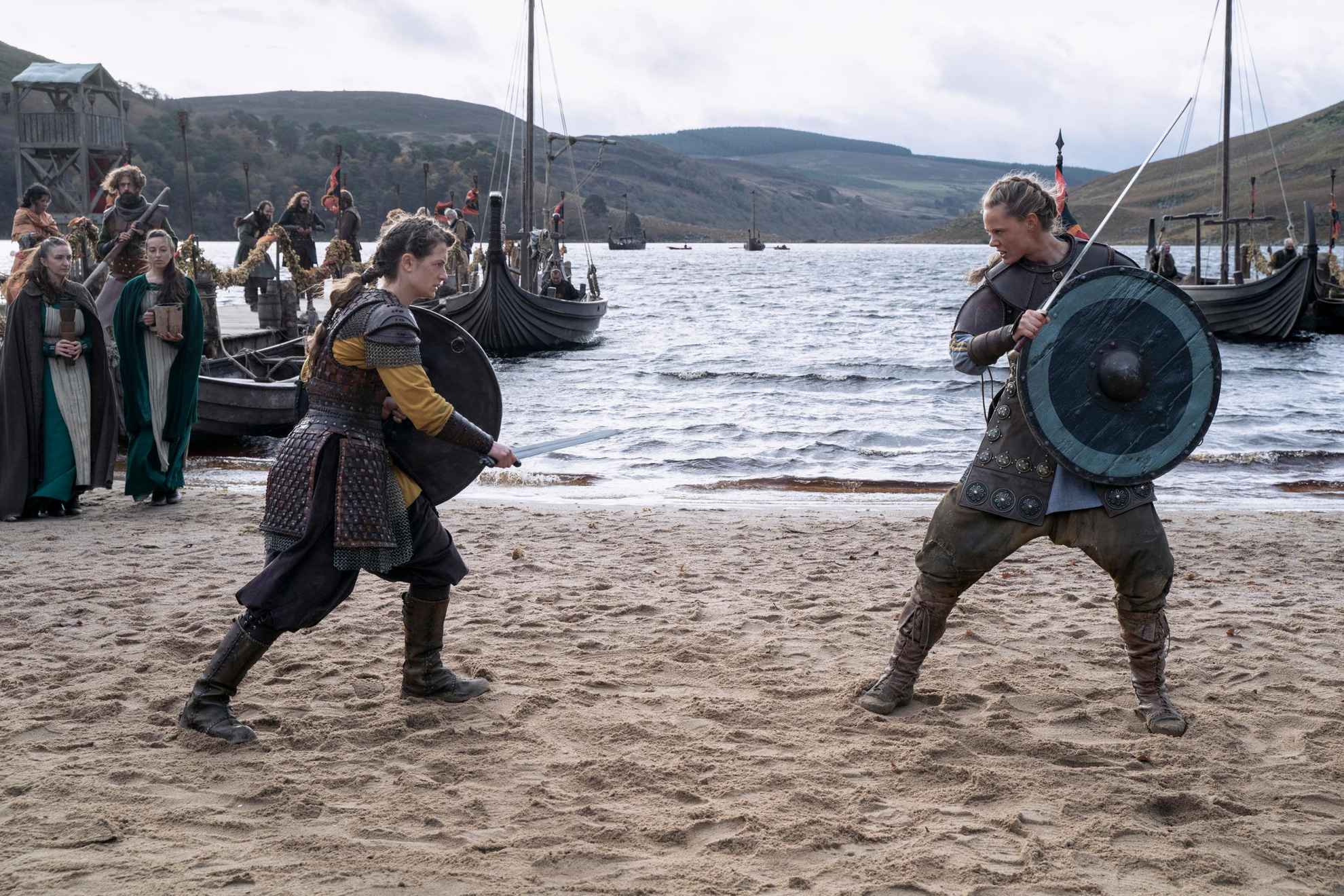 Zwei Wikingerinnen stehen an einem Strand und bereiten sich darauf vor, gegeneinander zu kämpfen. Aus der Fernsehserie Vikings: Valhalla.