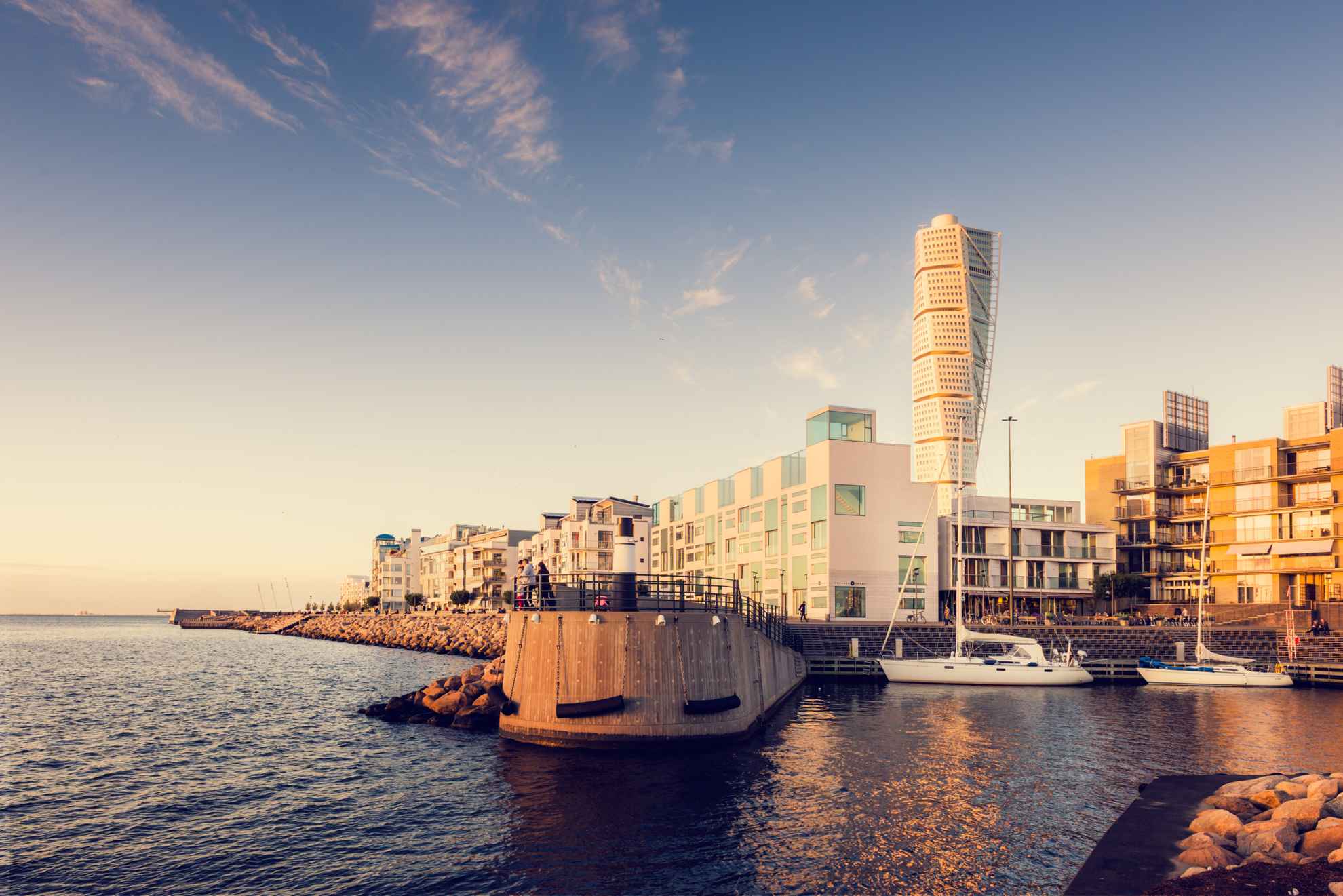 Zwei Segelboote liegen am Westhafen in Malmö vor Anker. Im Hintergrund ragt das Hochhaus Turning Torso auf.