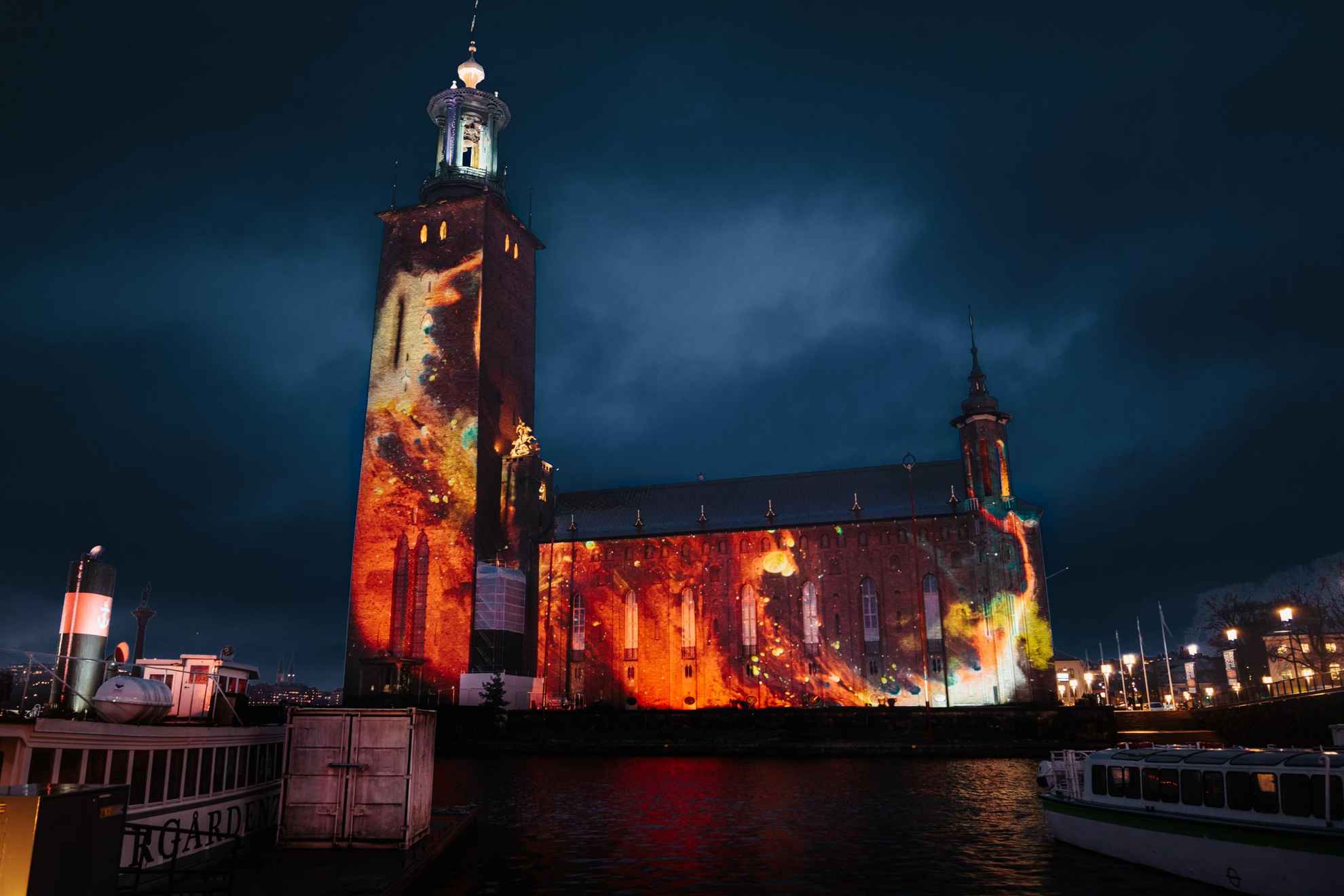 Das am Wasser gelegene Rathaus von Stockholm wird nachts von einer Lichtershow illuminiert.