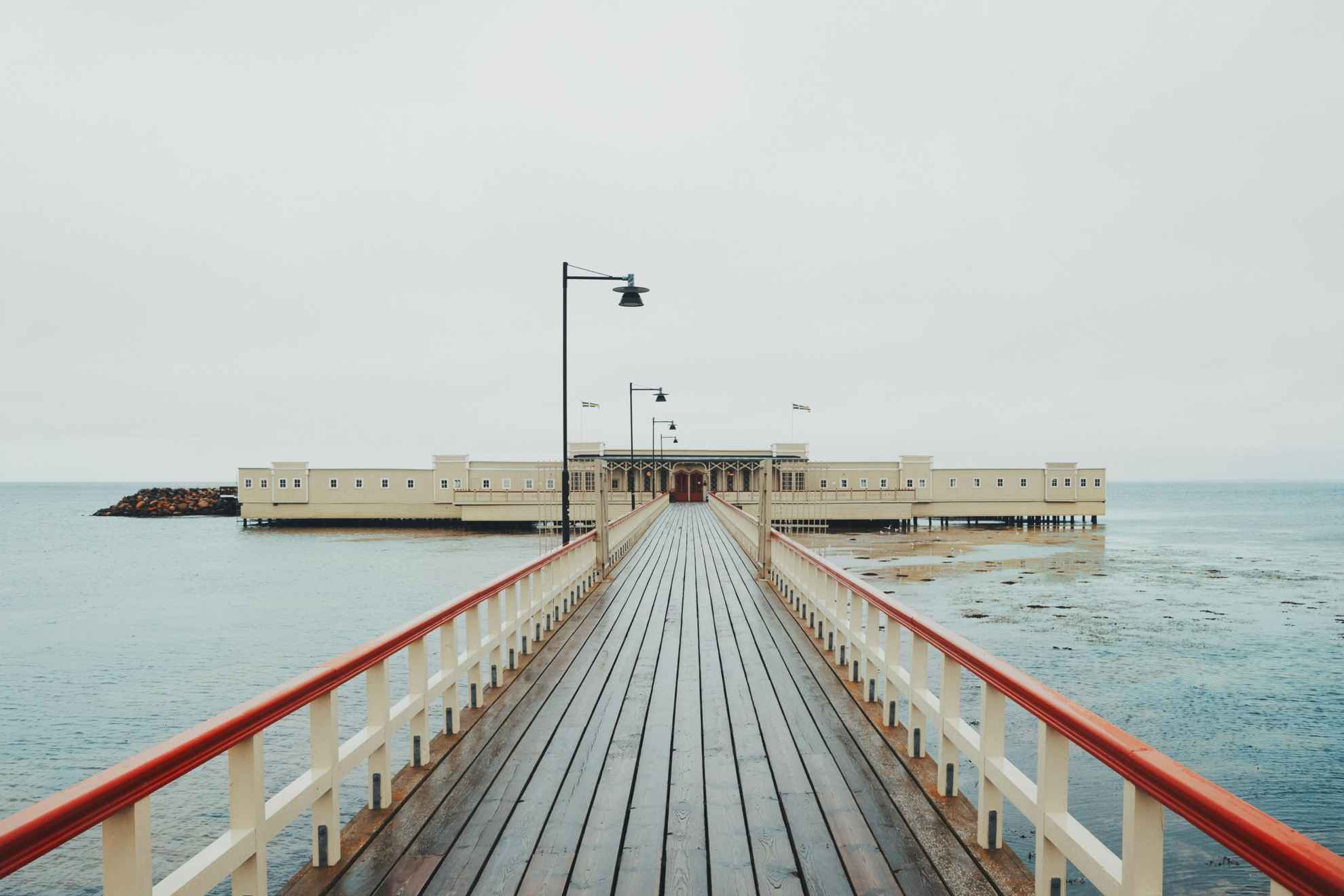 Ein langer hölzerner Pier, der zu einem Kaltwasserbadehaus in Malmö führt.