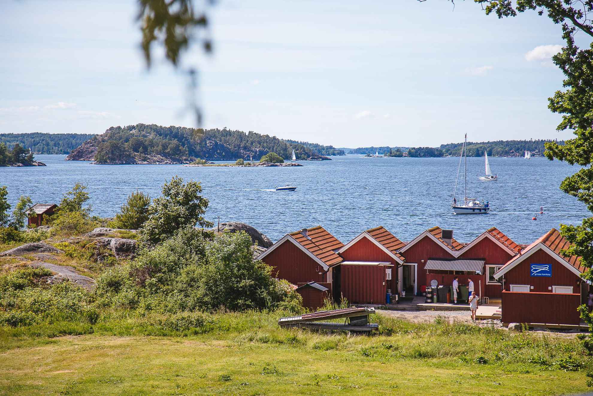 Rote Häuser am Ufer einer Insel im Schärengarten von Stockholm