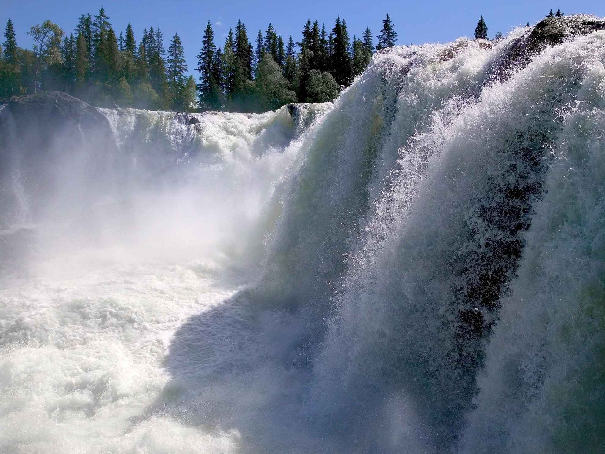 Einer der größten Wasserfälle Schwedens. Im schäumenden Wasser glitzert das Licht der Sonne.