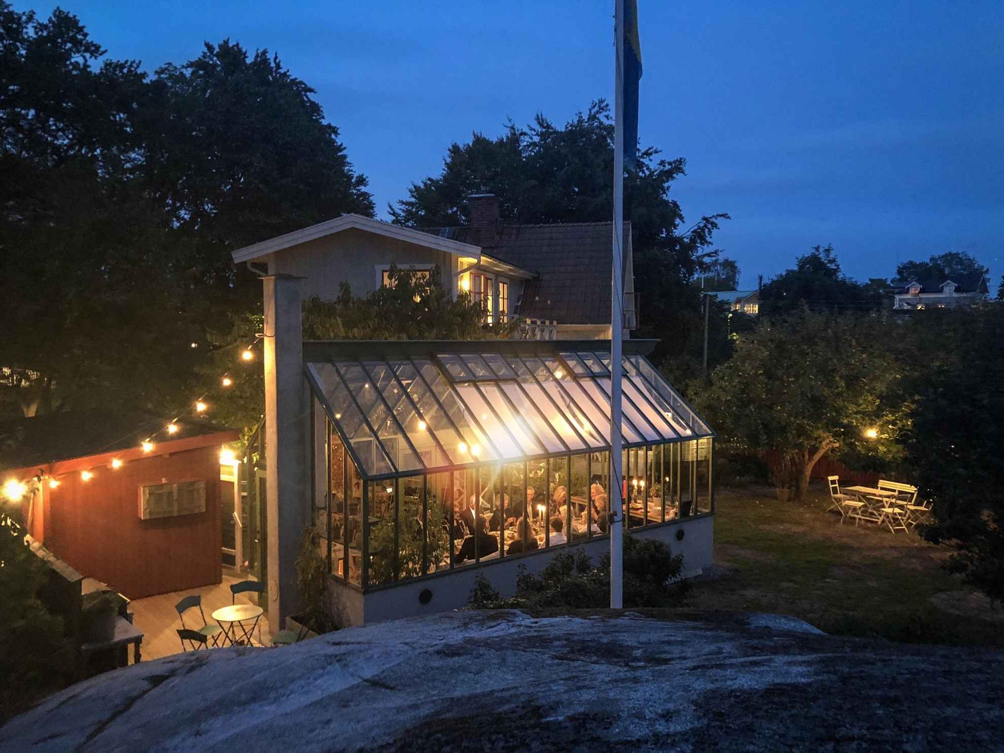 Ein Restaurant in einem schicken Gartenhaus. Es ist Abend und zahlreiche Lichterketten sorgen für eine gemütliche Atmosphäre.