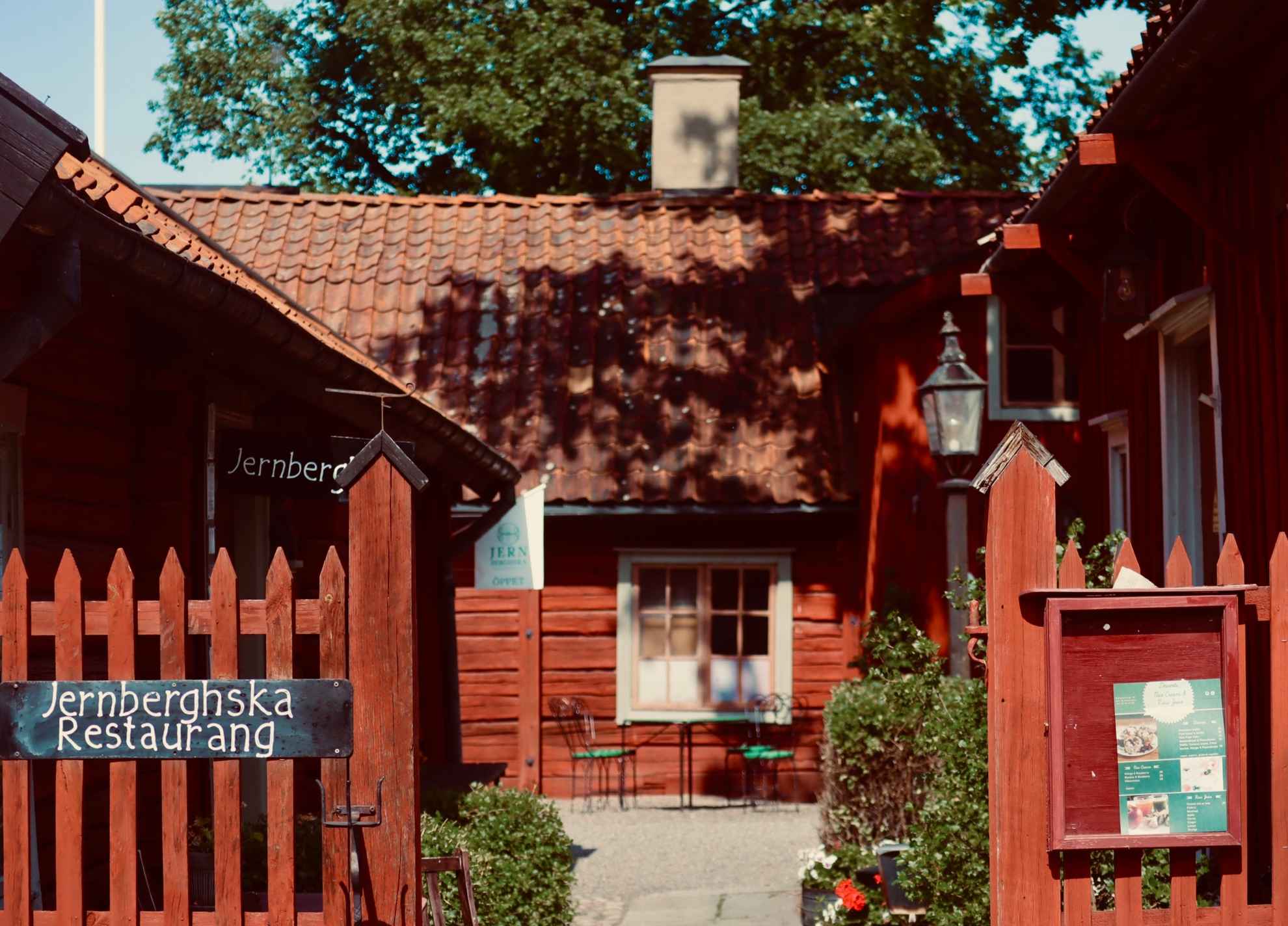 Rote Lattenzäune vor roten Holzhäusern im Freilichtmuseum Rademacher Forges in Eskilstuna.