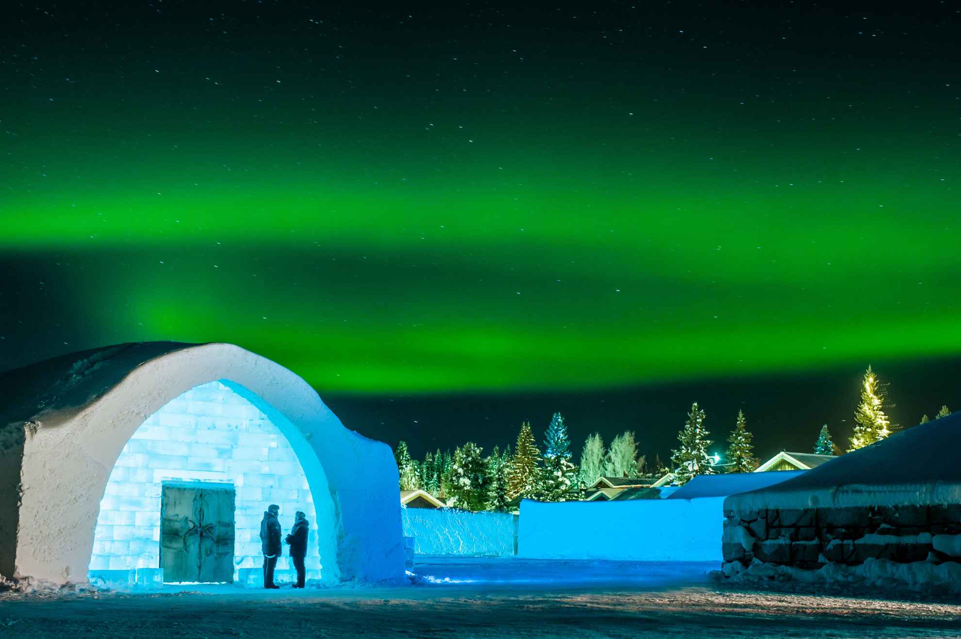 Grüne Nordlichter leuchten über dem Eingang zum Icehotel in Schweden.