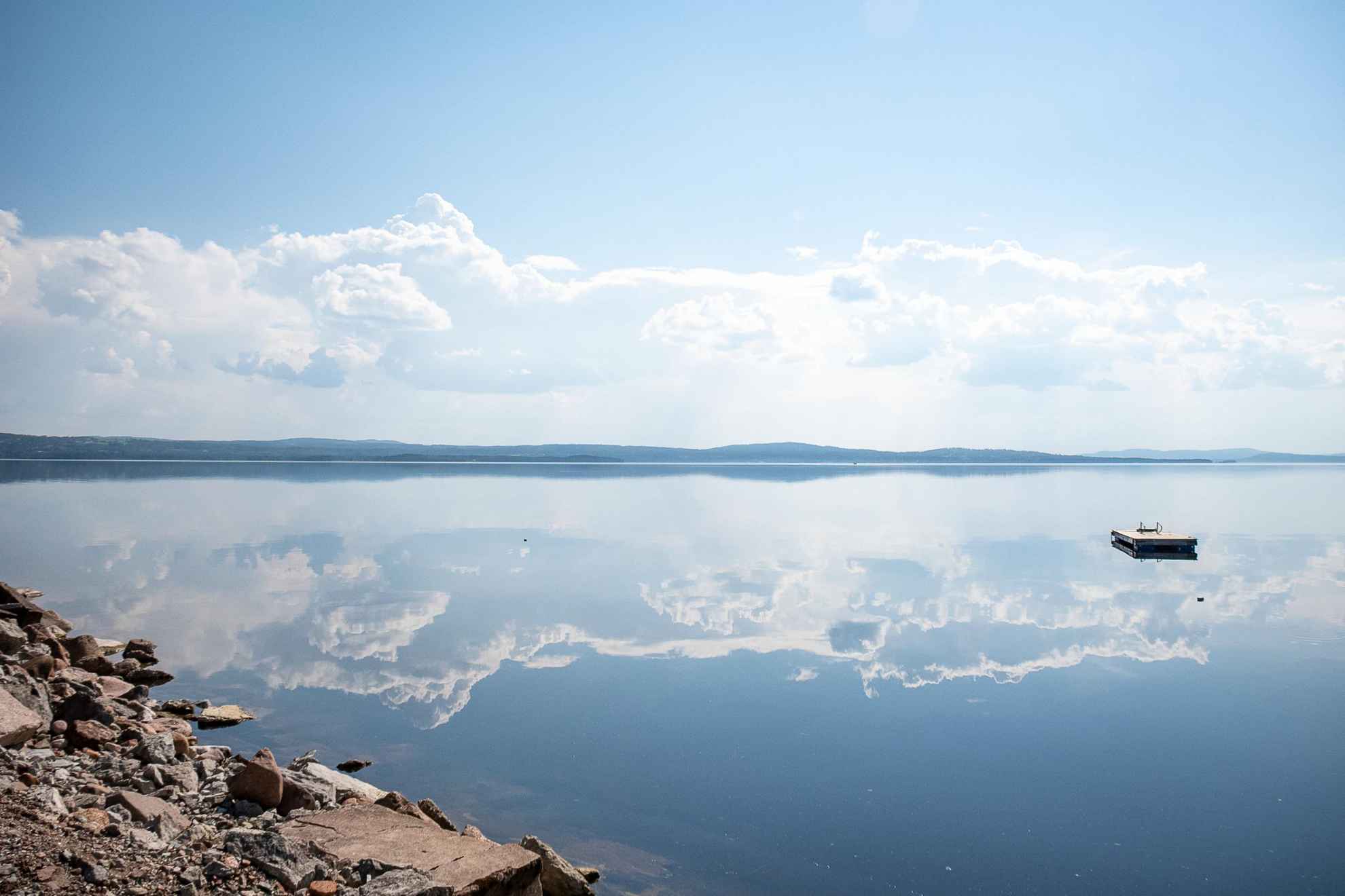 Der Siljansee an einem Sommertag. Wolken spiegeln sich in seinem Wasser.