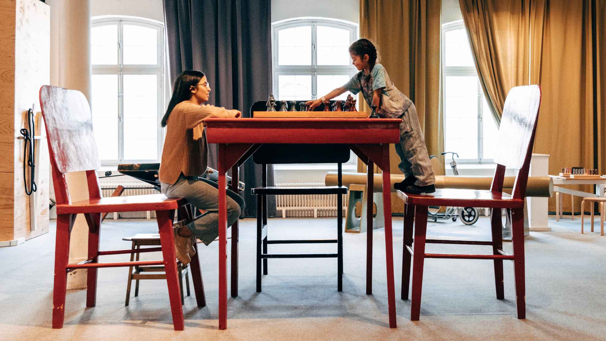 Frau und Kind spielen Schach an einem riesigen Tisch bei Tom Tits