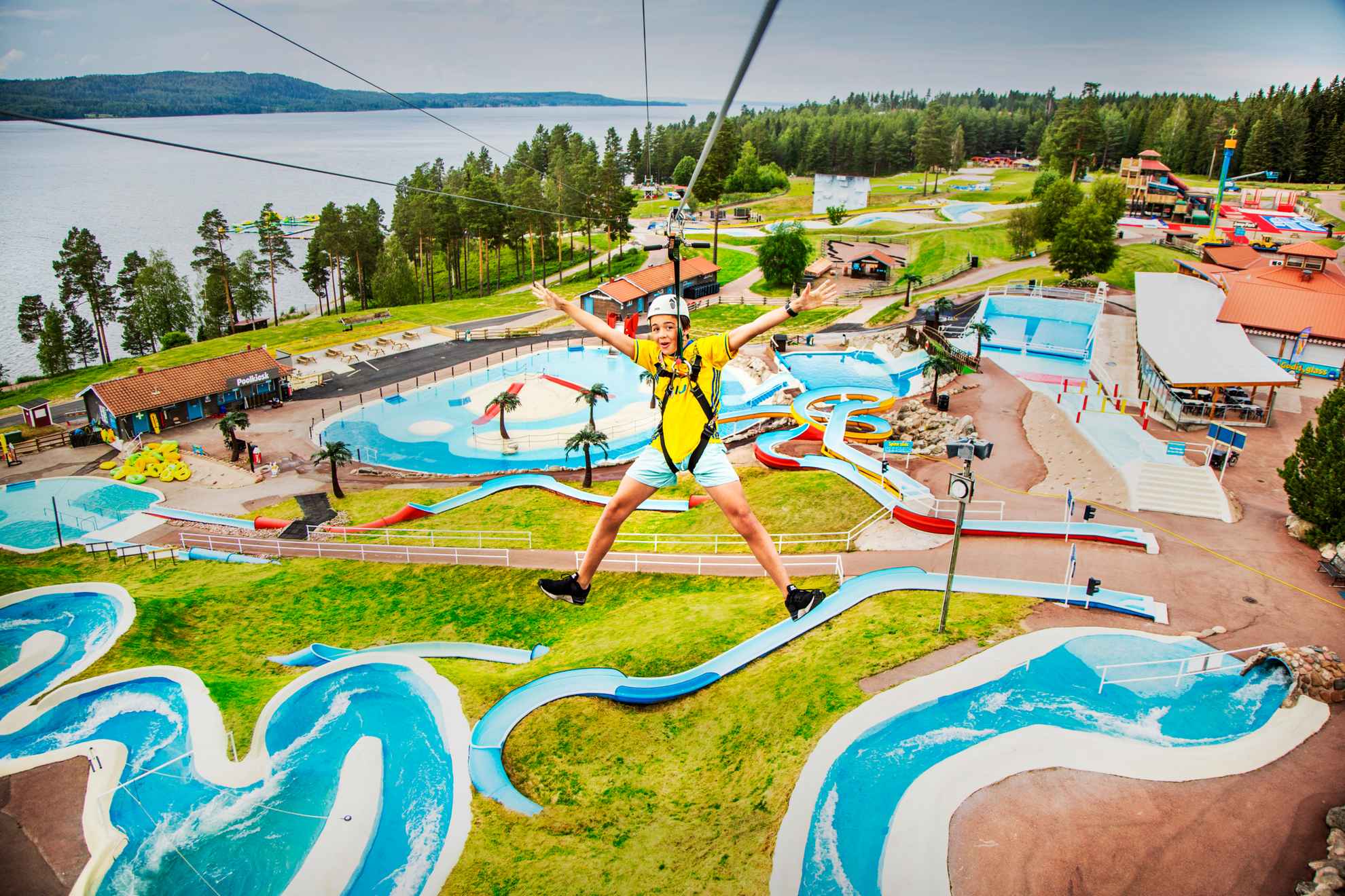 A child rides a zipline over the water park at Leksand Sommarland.