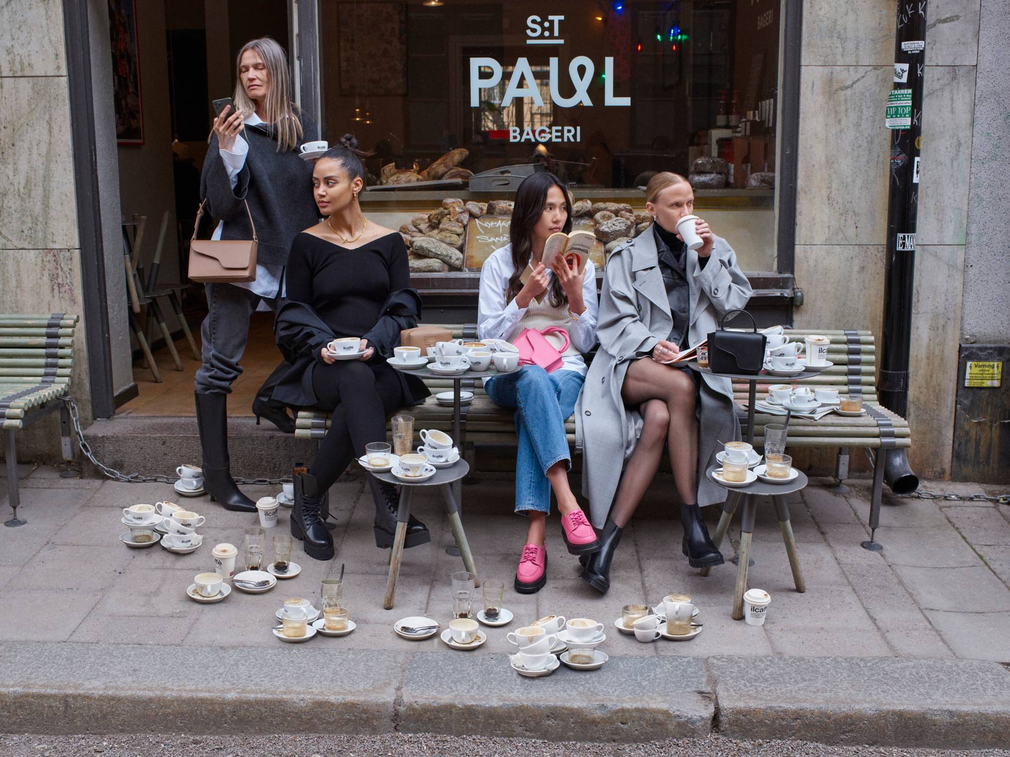 Models sitzen vor einem Café in Stockholm.
