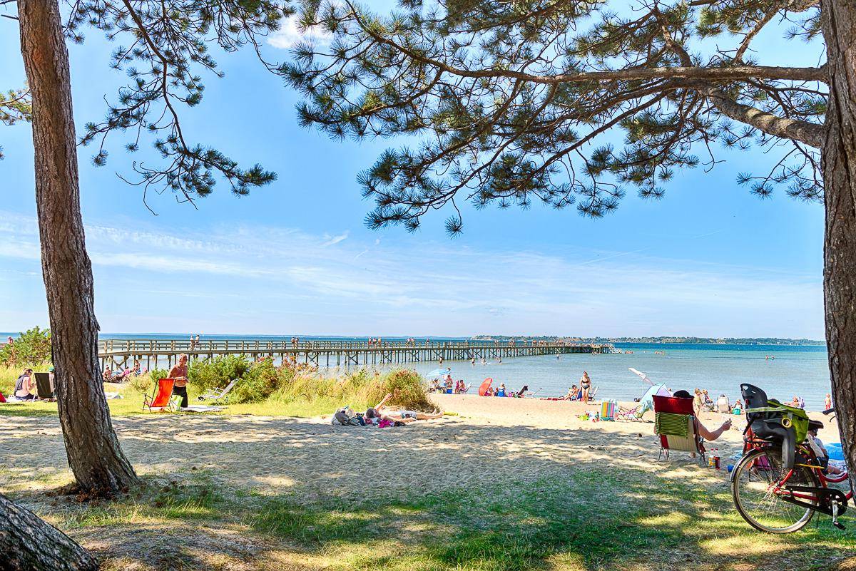 Menschen entspannen sich an einem sonnigen Tag an einem Strand.