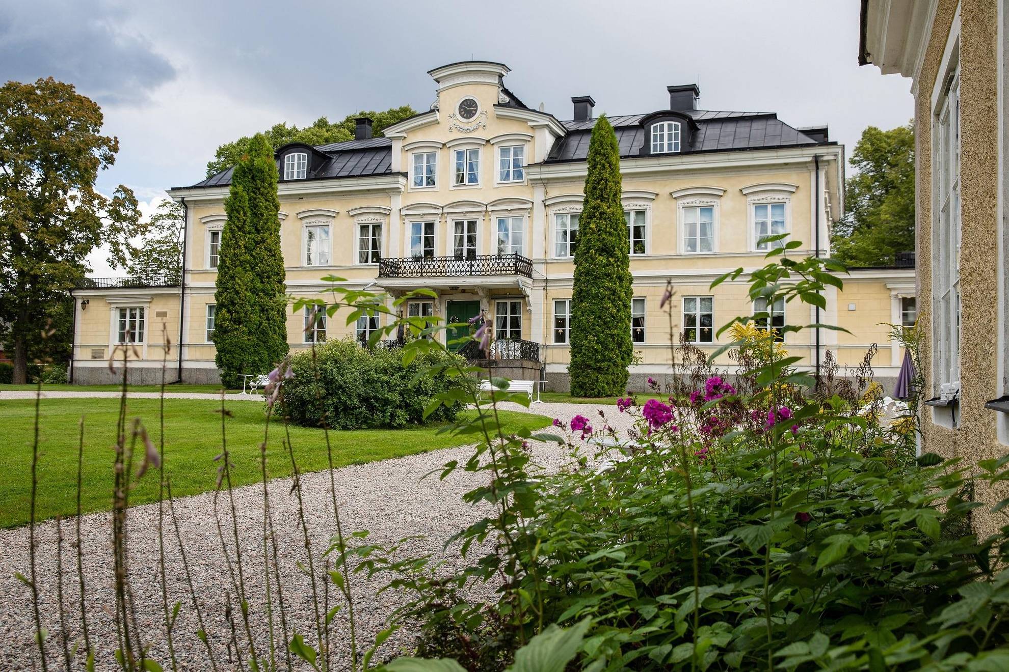 Das Gebäude des Herrenhauses Färna, umgeben von viel Grün an einem Sommertag.