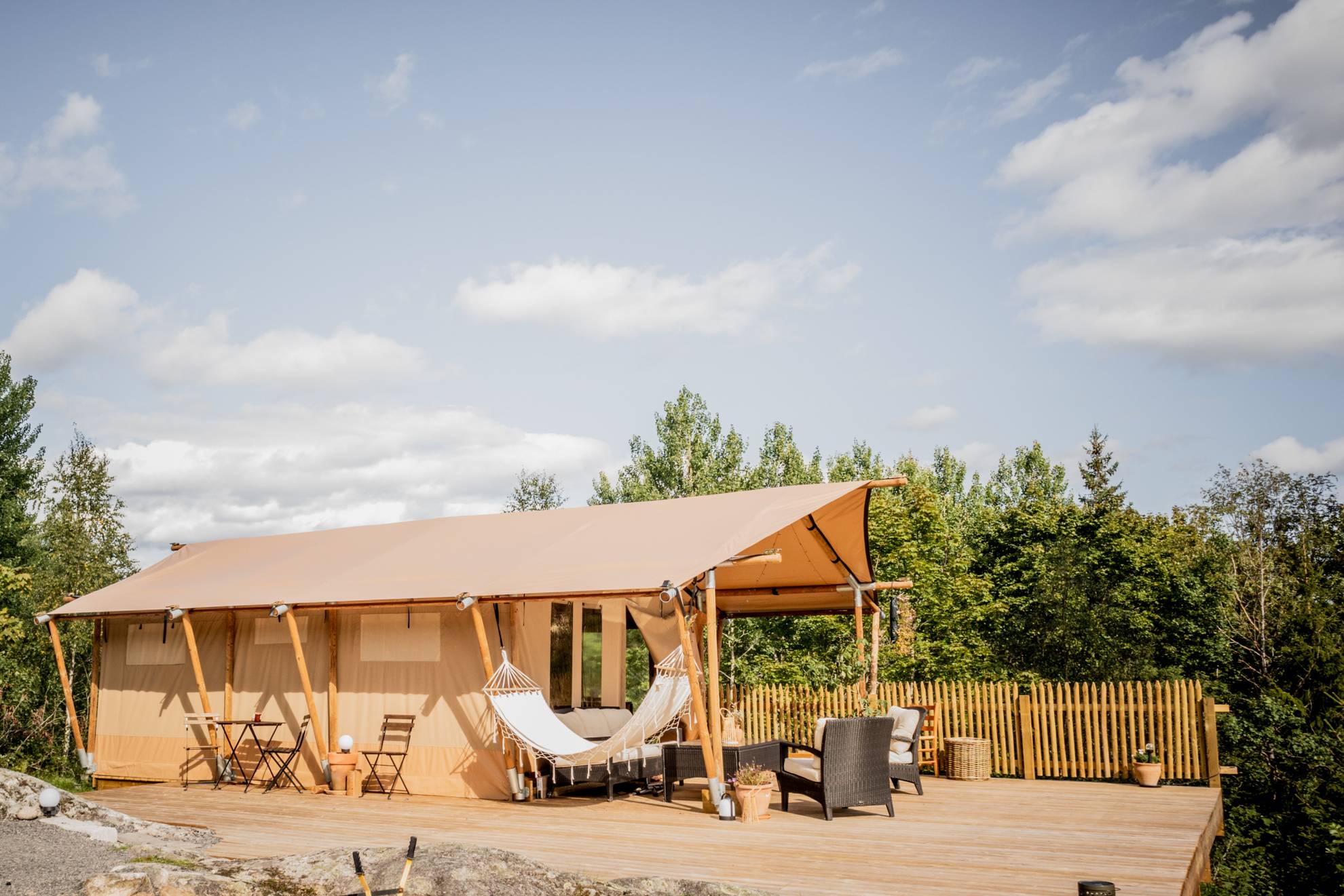 Remjeng Retreat in Värmlandmit einem Innenhof. Eine Unterkunft mit einem Innenhof. Es gibt eine Hängematte und Stühle vor der Unterkunft.
