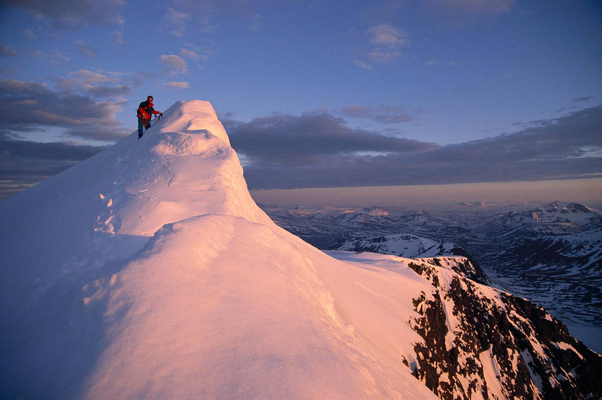 Eine Person steht auf einem schneebedeckten Berg.