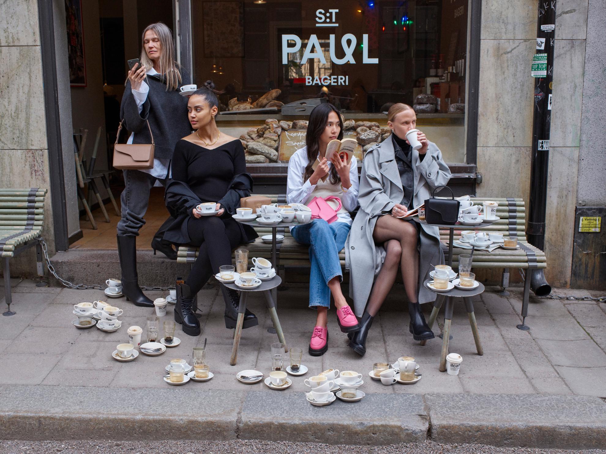 4 Models sitzen außerhalb eines Cafes in Stockholm.