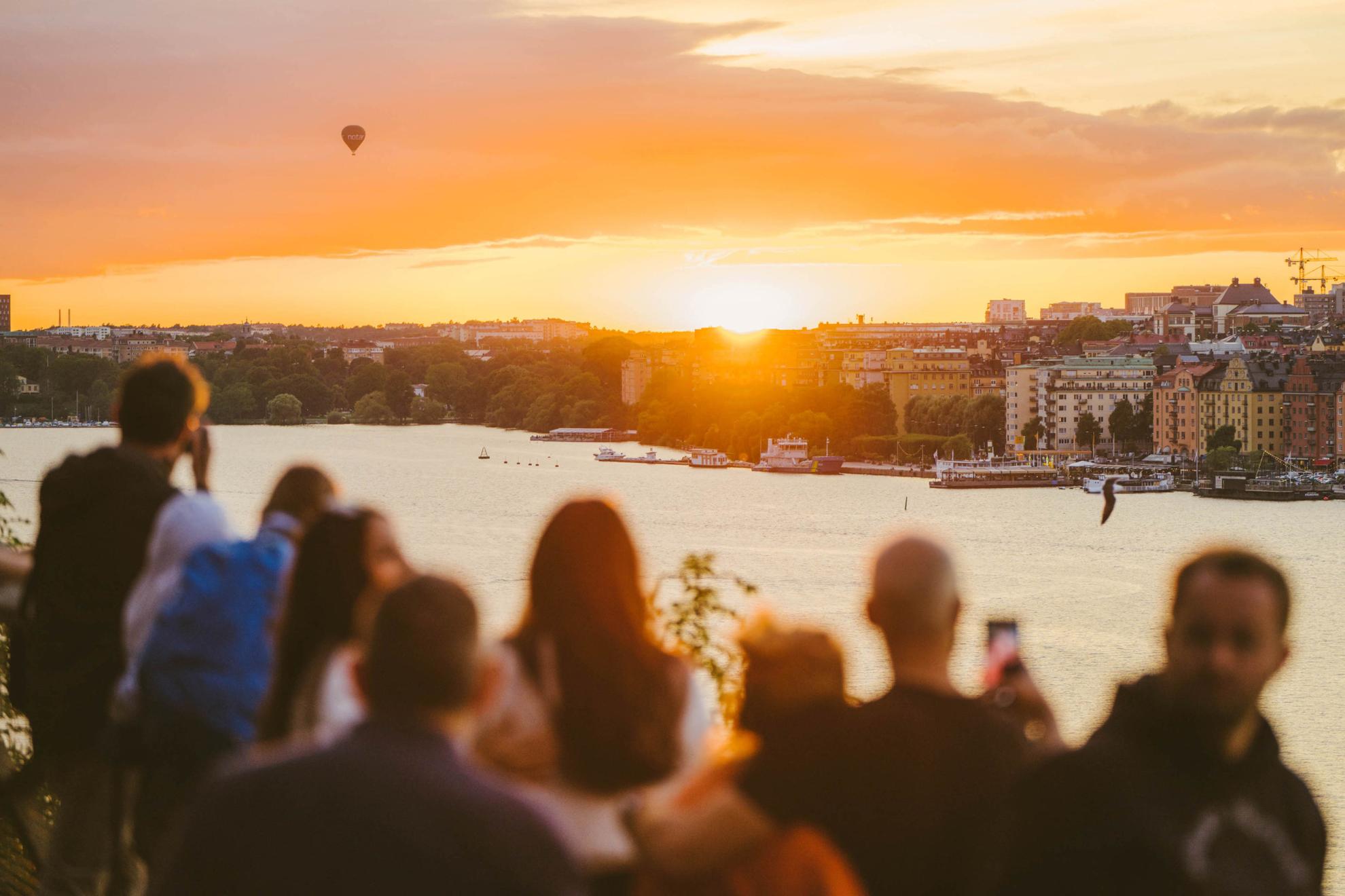 Eine Gruppe von Menschen beobachtet den Sonnenuntergang in Stockholm.