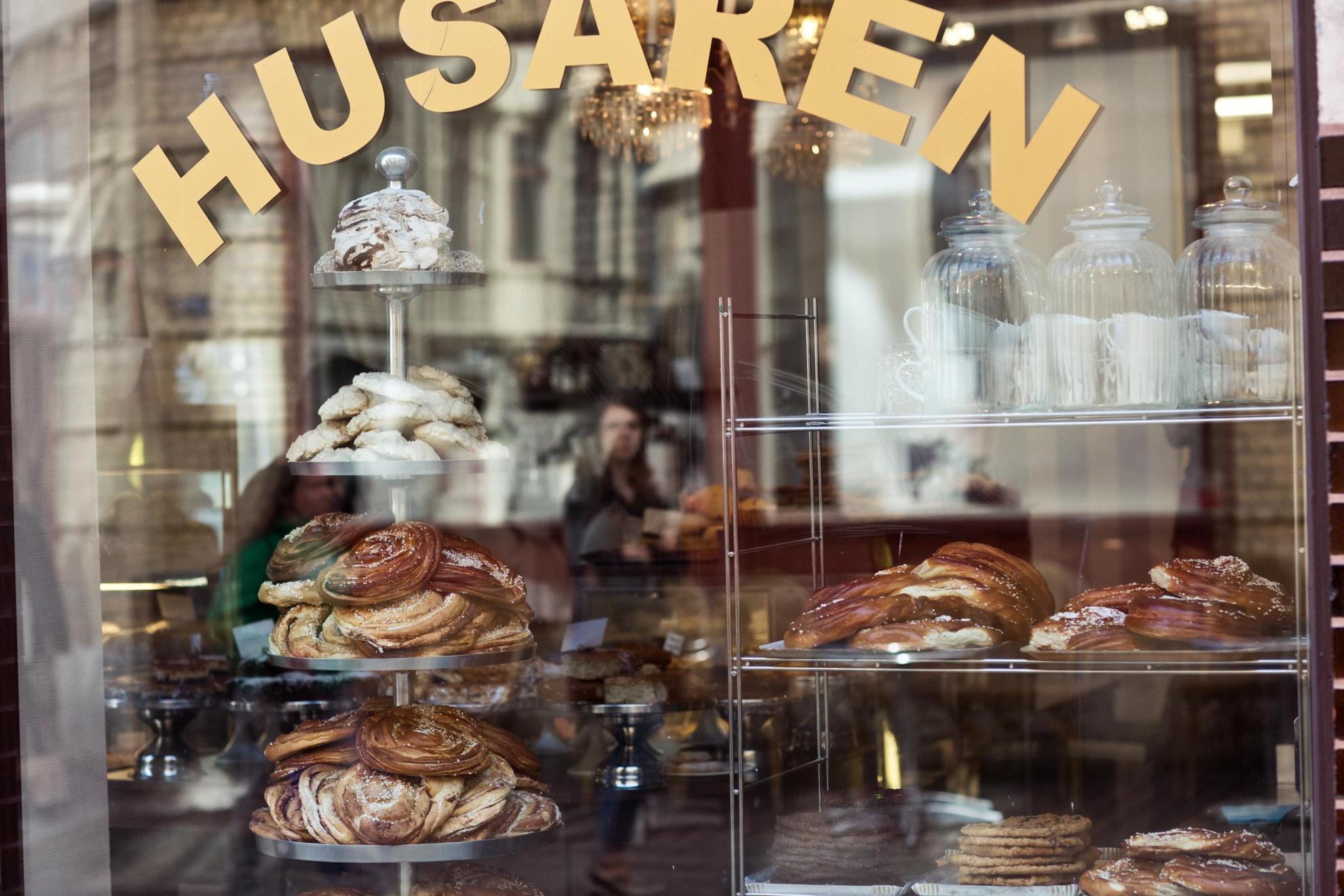 Large Swedish cinnamon buns, cookies and meringues seen through the display window of a bakery.