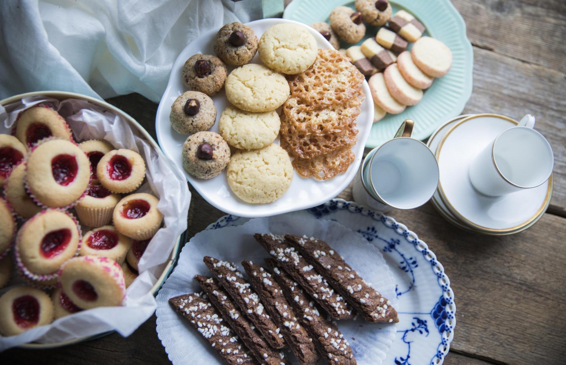 Sieben Arten von schwedischen Keksen liegen auf mehreren Tellern verteilt.