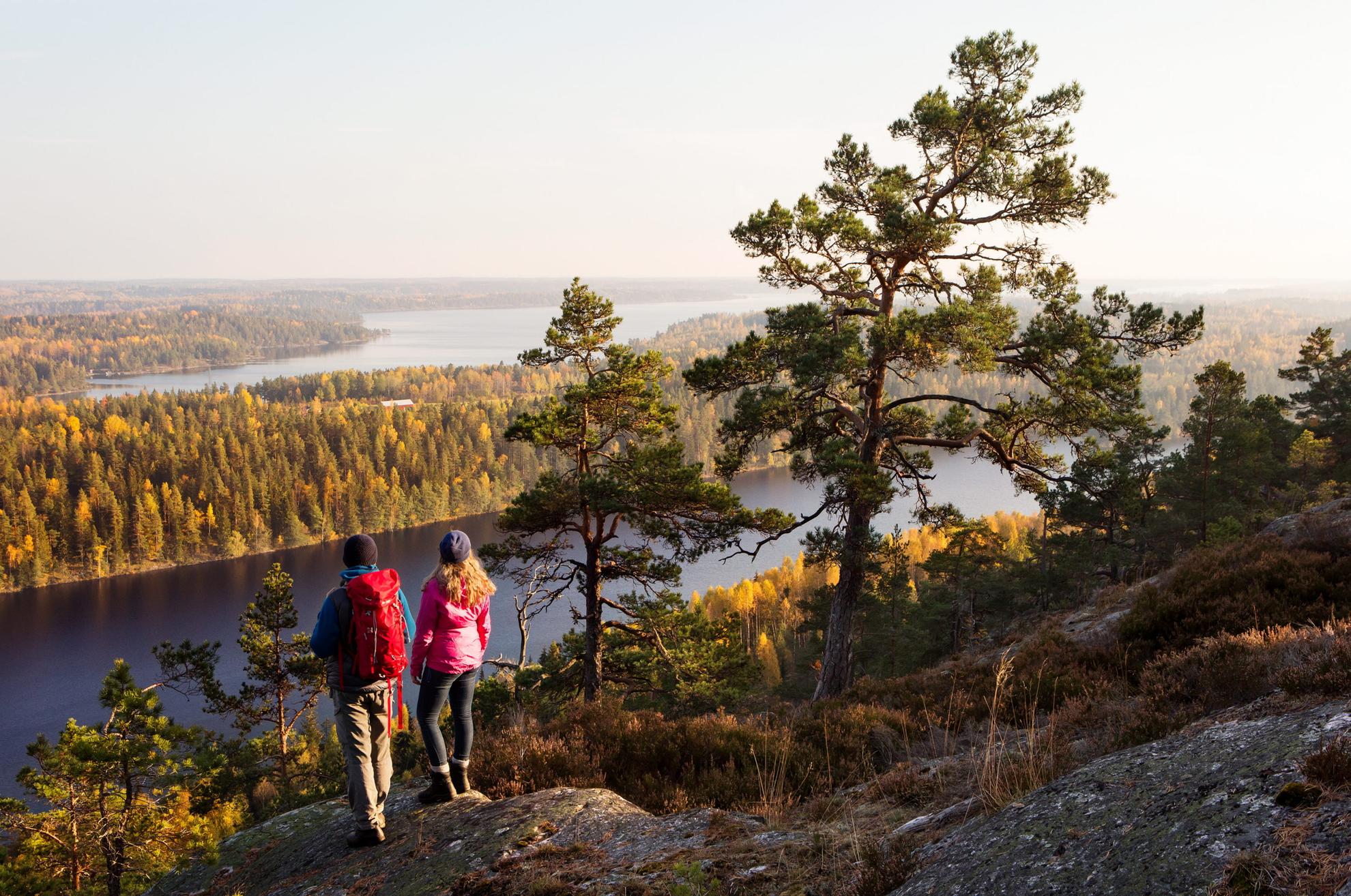 Zwei Menschen wandern in Westschweden in der herbstlichen Natur und genießen ihren Herbsturlaub in Schweden.