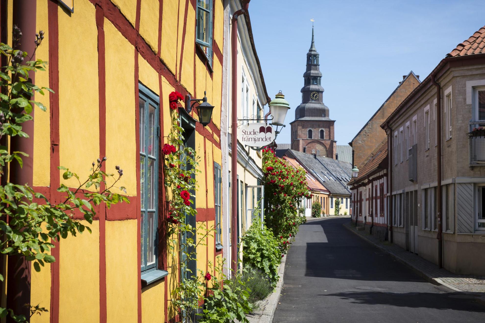 Eine Straße in Ystad mit alten Häuschen und einem Pflastersteinweg.