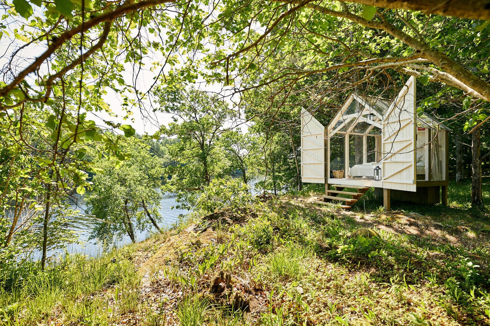 Eine Hütte aus Holz und Glas in der Natur während des Sommers.