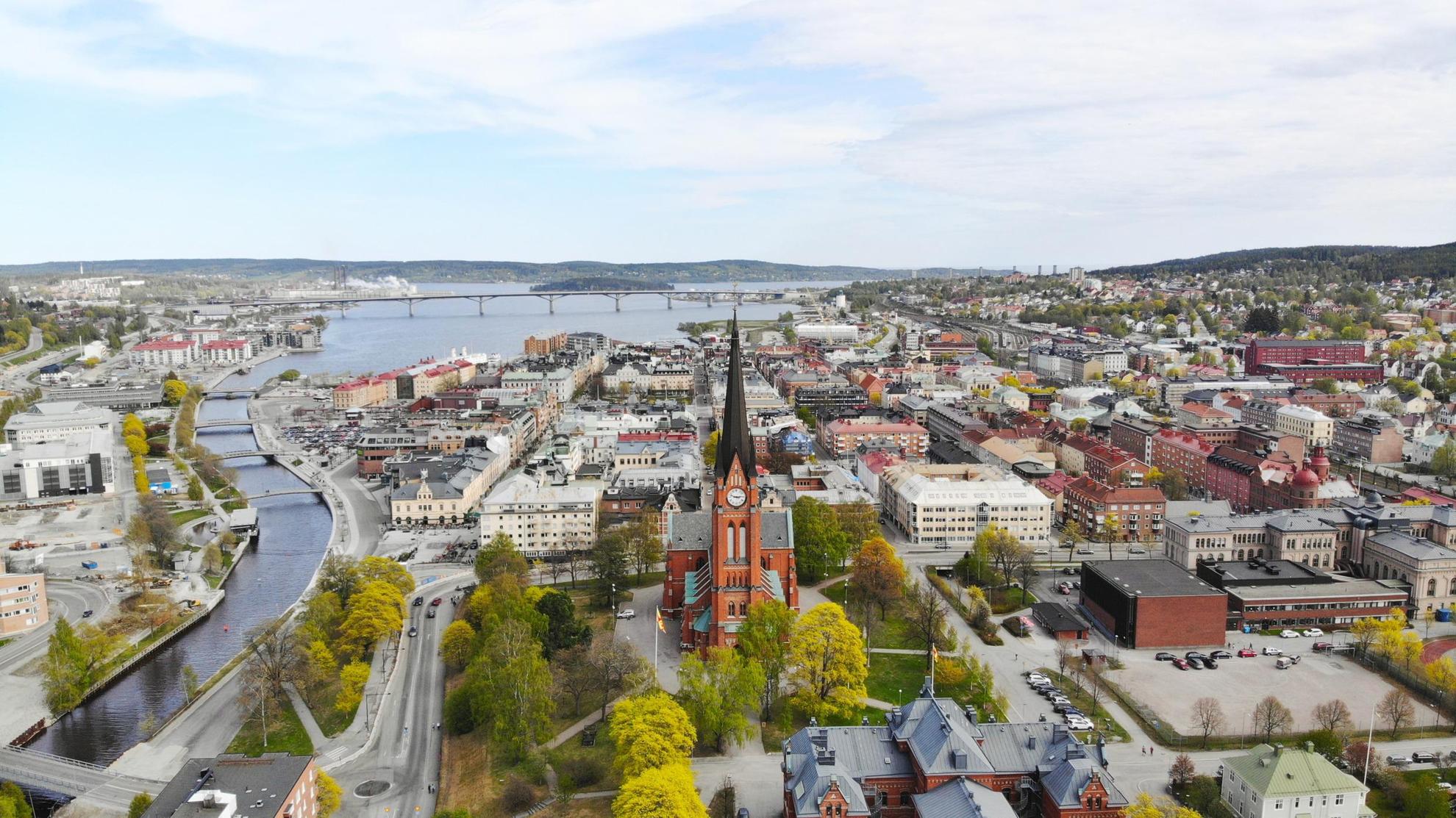 Luftaufnahme der Stadt Sundsvall und der Umgebung. Im Mittelpunkt des Bildes steht die im gotischen Stil erbaute Kirche „Gustav Adolfs kyrka“ mit hohem Turm.