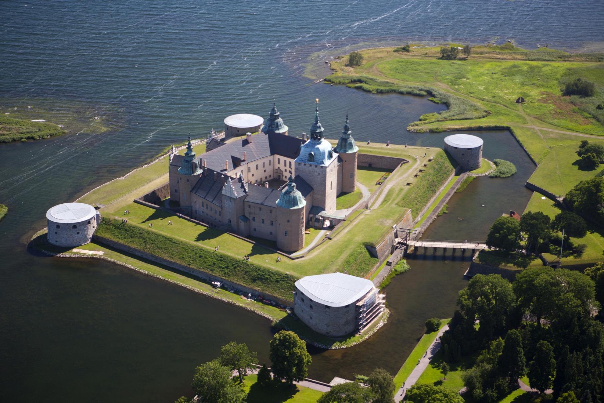 Luftaufnahme von Schloss Kalmar auf einer kleinen Insel, umgeben von Wasser mit einer kleinen Brücke zum Festland.